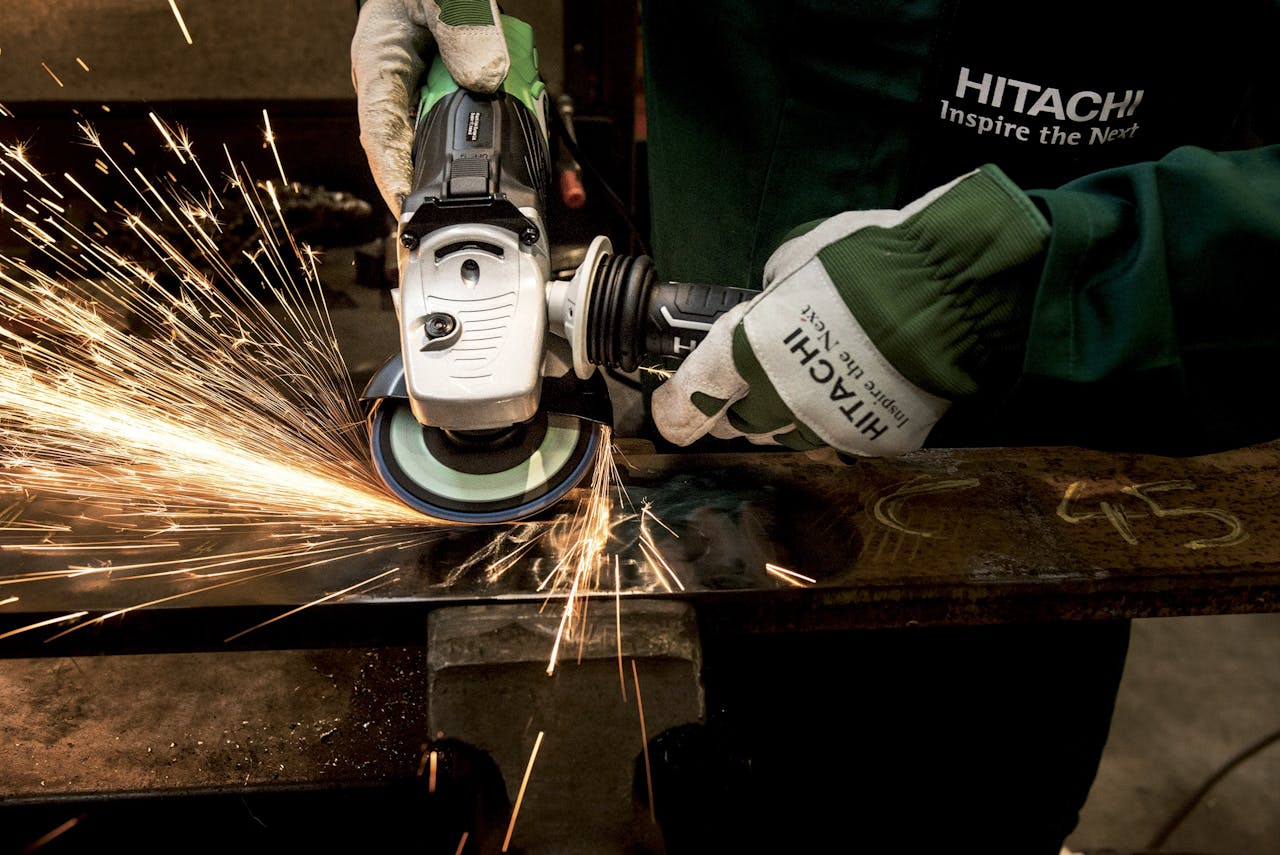 mobile-01 Close-up of a skilled worker using a grinder with sparks flying in a metal workshop.