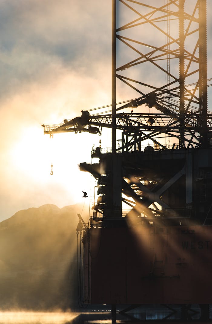 digital-01 Dramatic silhouette of industrial machinery against a foggy morning sunrise, capturing the essence of heavy industry.