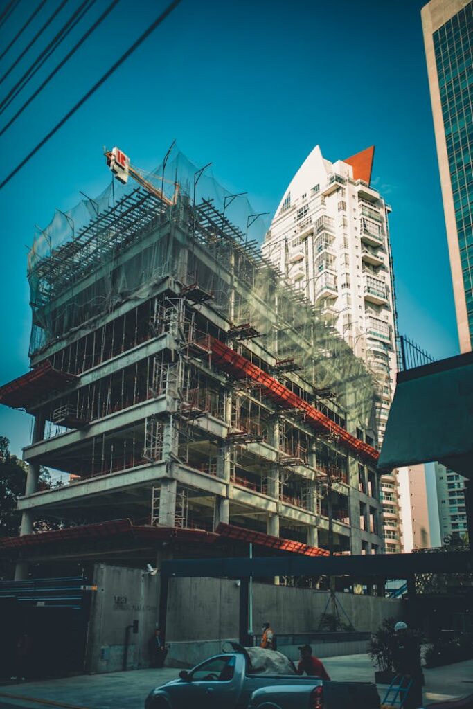 pexels photo 2100681 High-rise building under construction with scaffolding and crane in urban cityscape.